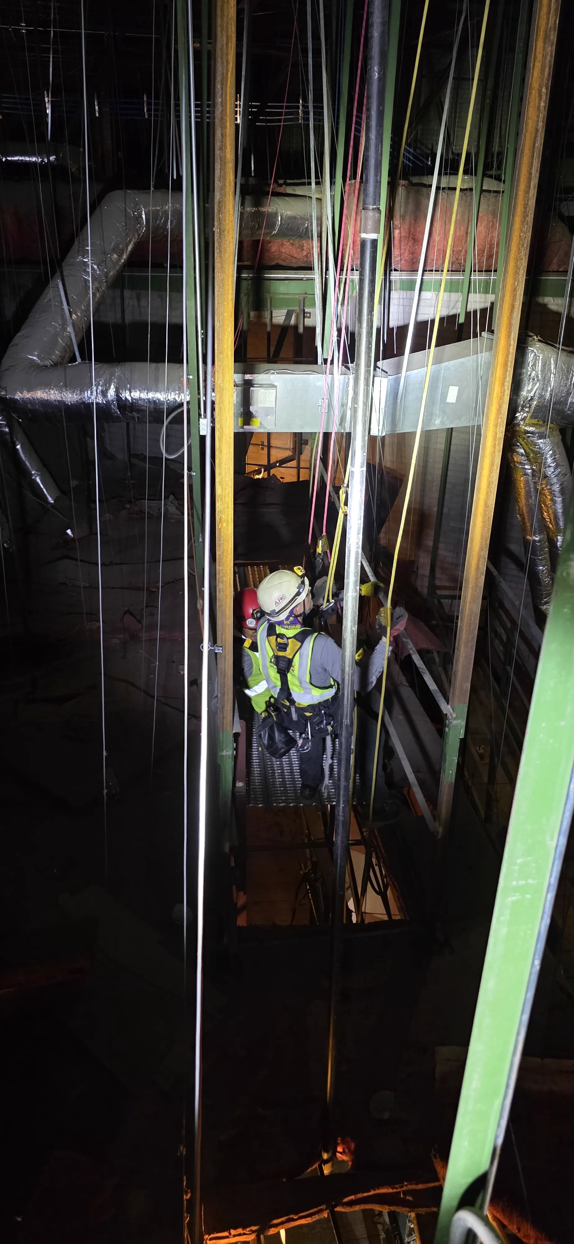 ARS technician descending into a high-bay industrial shaft