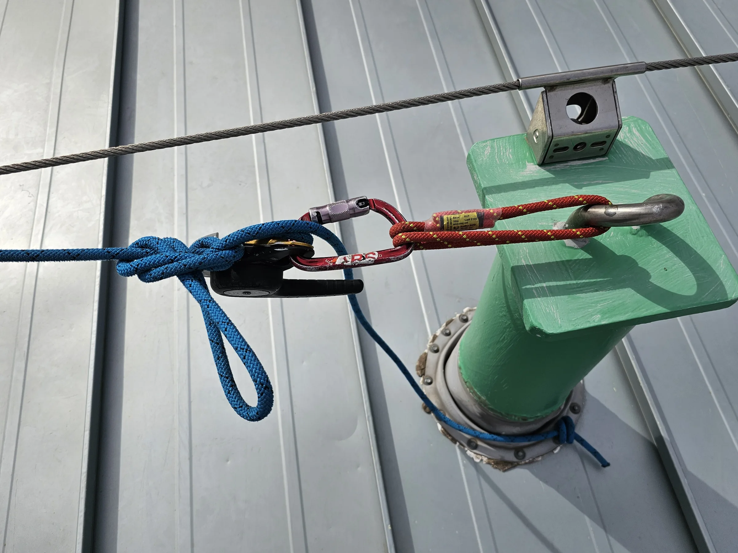 Close view of rope-access anchor hardware arranged on a rooftop