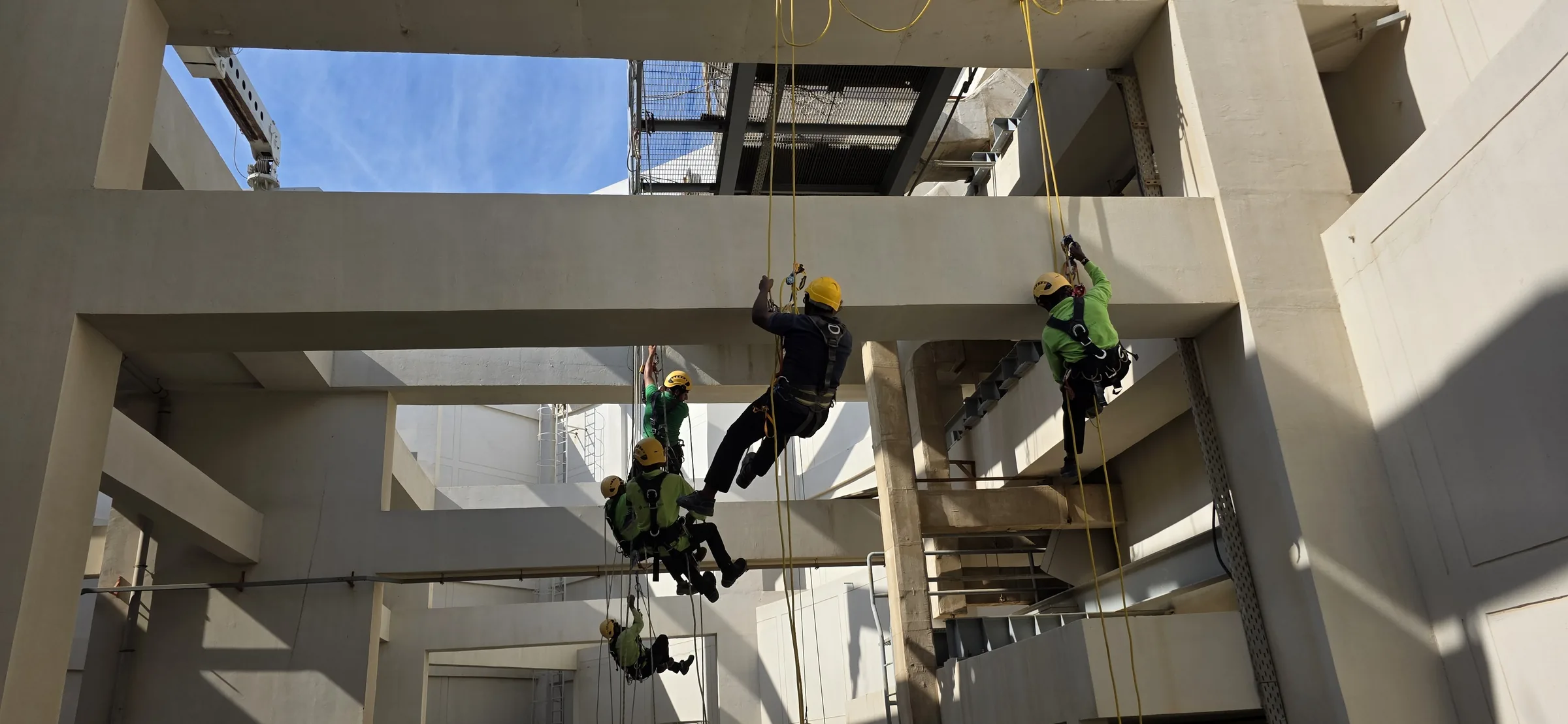 Rope-access trainees positioned on lines during a supervised facade exercise