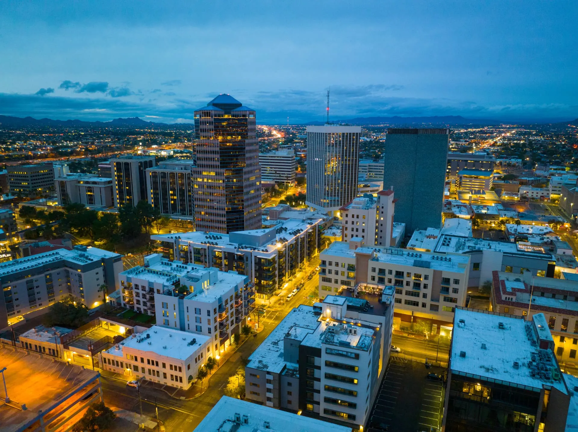 Downtown Tucson at dusk with lit high-rise buildings, rope access, confined space rescue and safety services in Tucson, AZ
