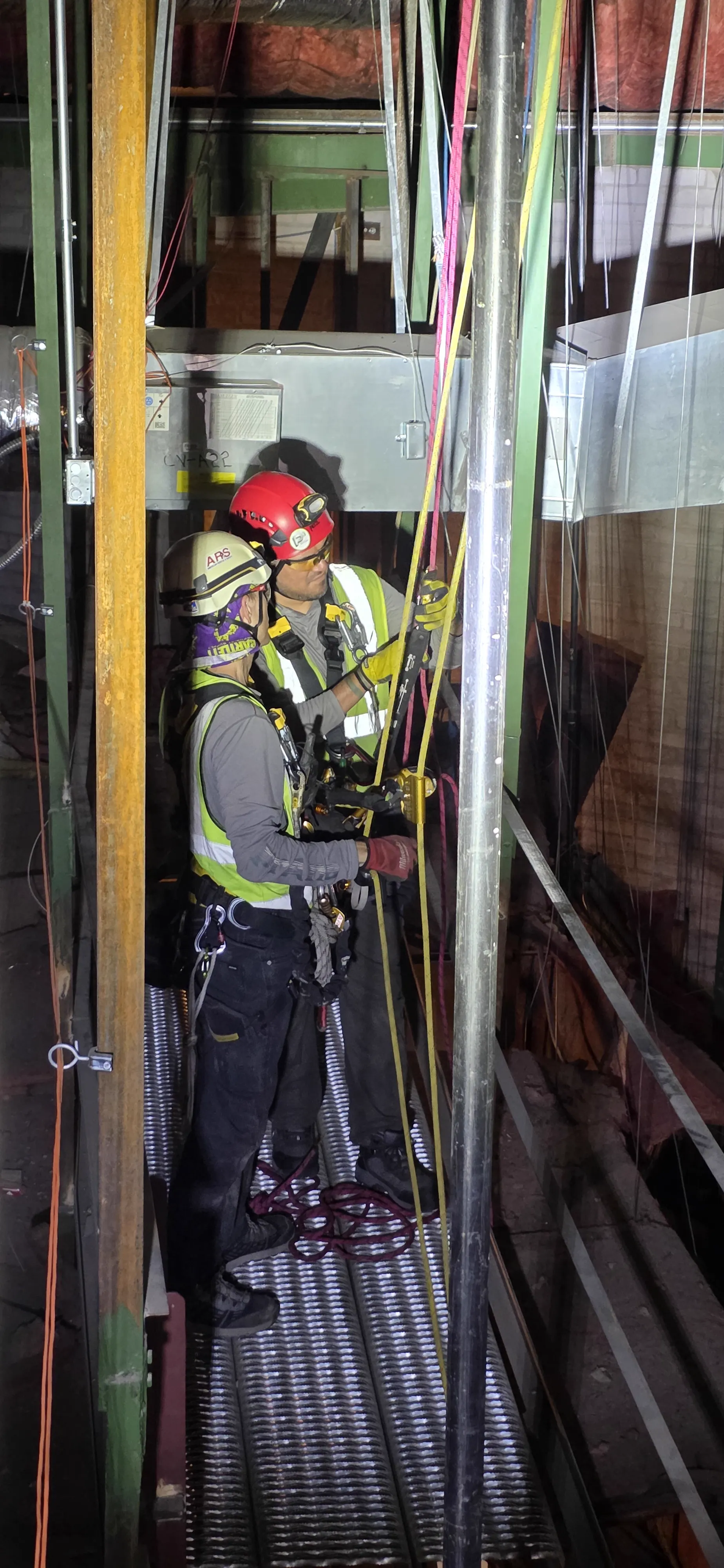 ARS technician in harness and helmet staged at a shaft access doorway