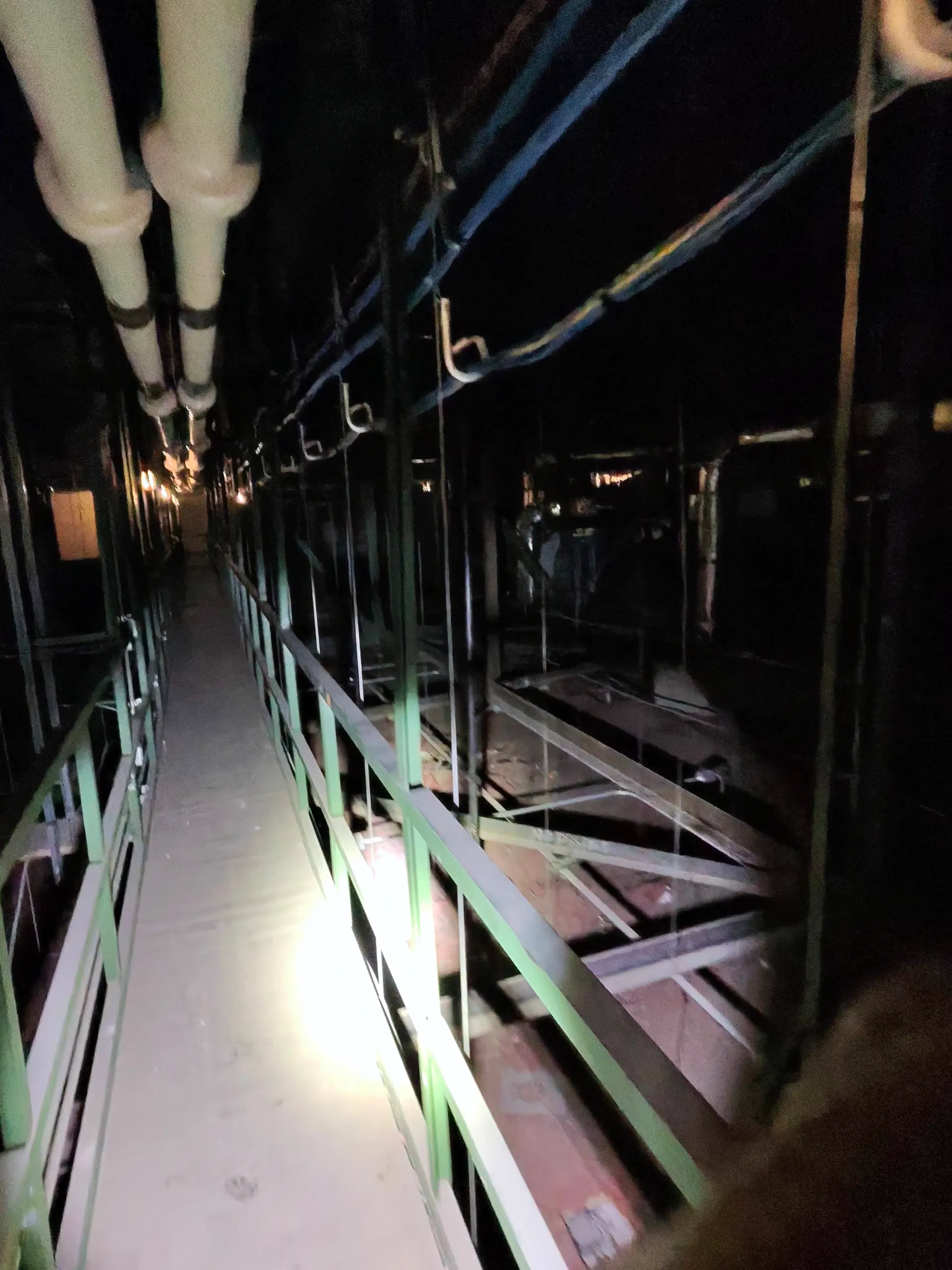 Illuminated interstitial walkway route through overhead building services