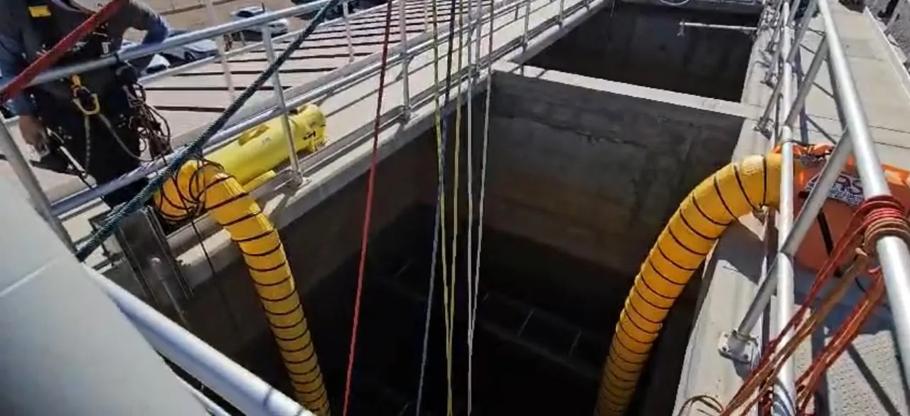 Open vault entry with rigged ropes and yellow ventilation ducting running into the space