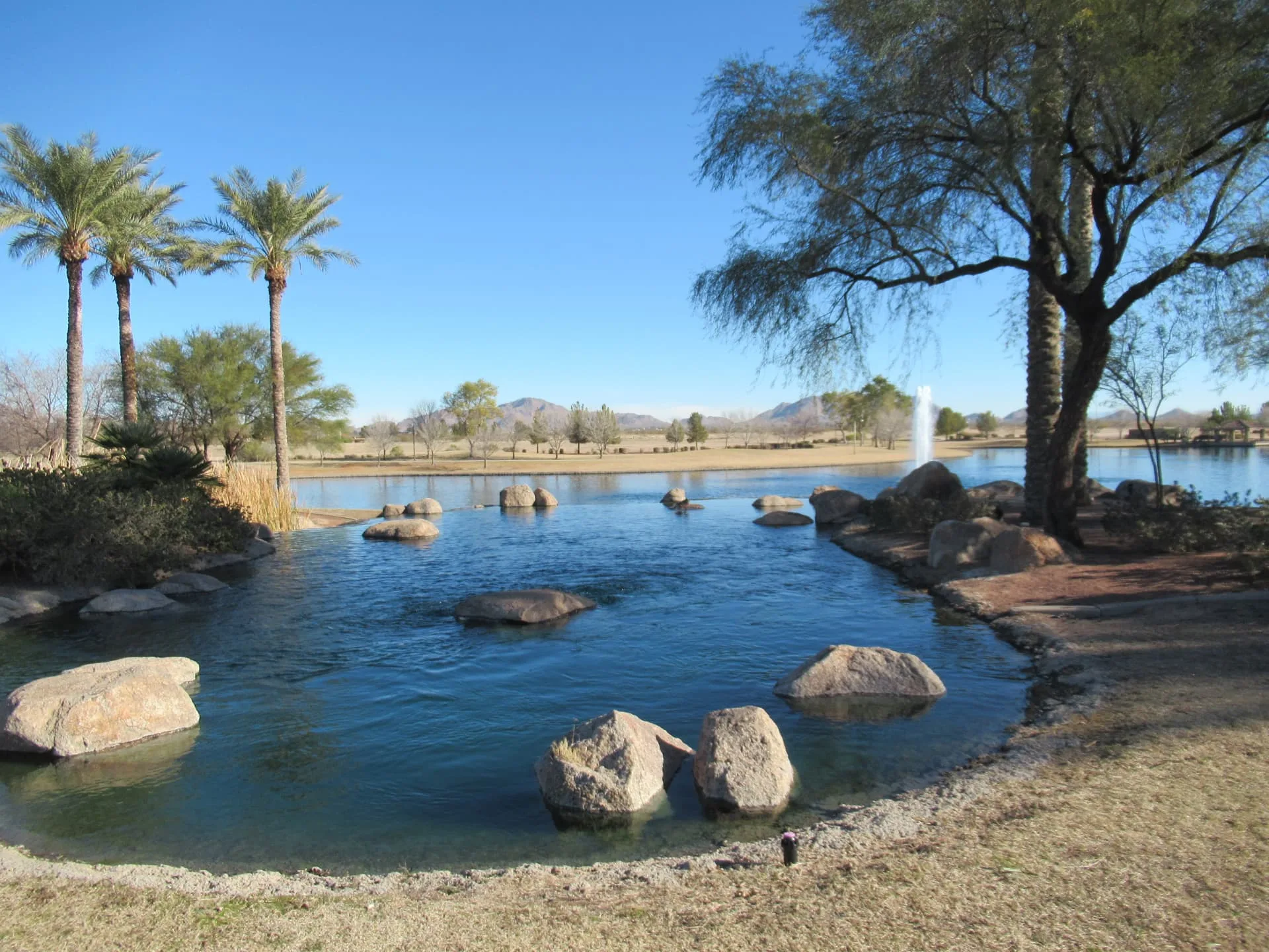 Casa Grande area community lake with palms and desert mountains beyond, rope access, confined space rescue and safety services in Casa Grande, AZ