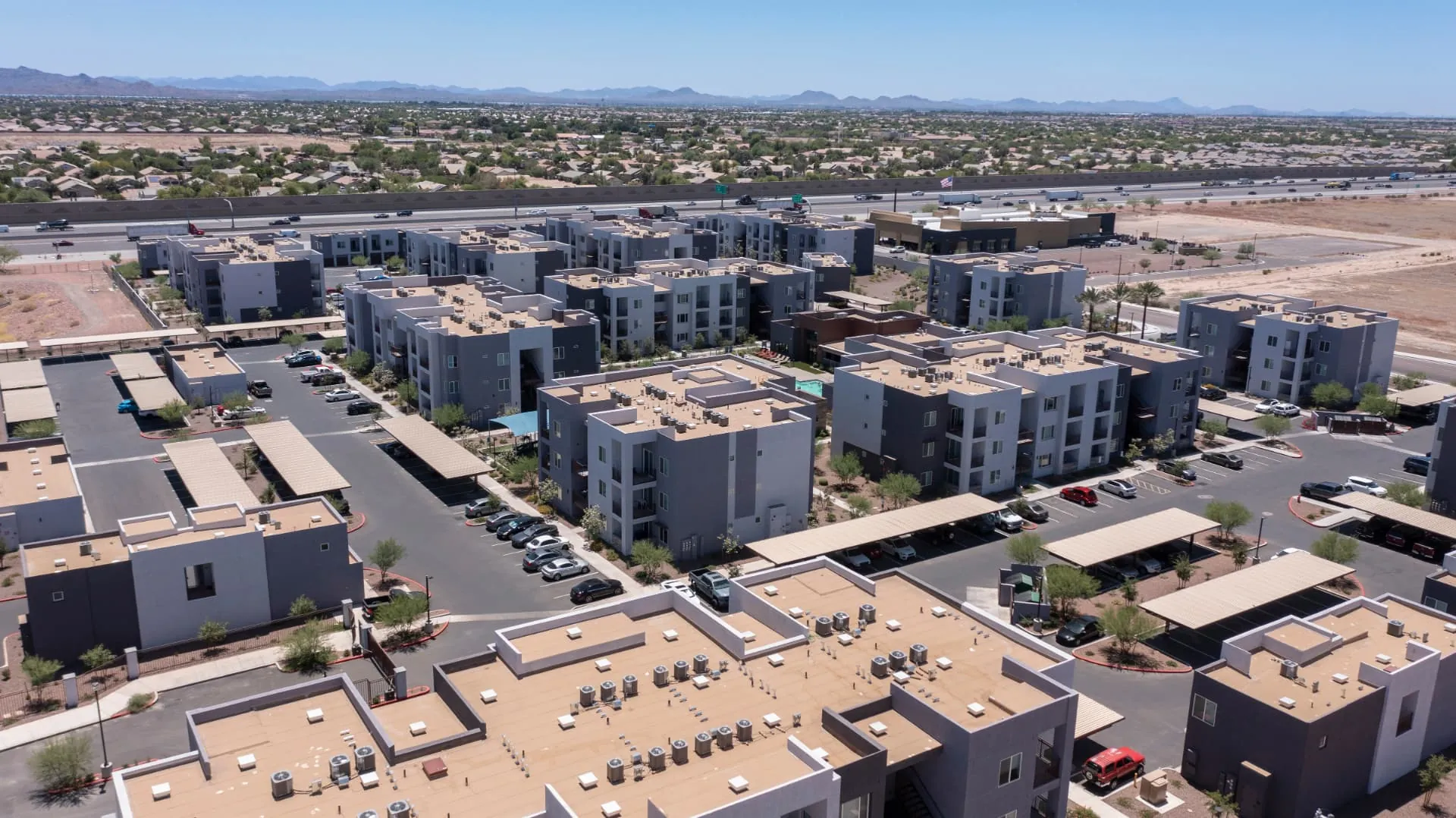 Aerial view of multifamily buildings and rooftop mechanical equipment near I-10 in Goodyear