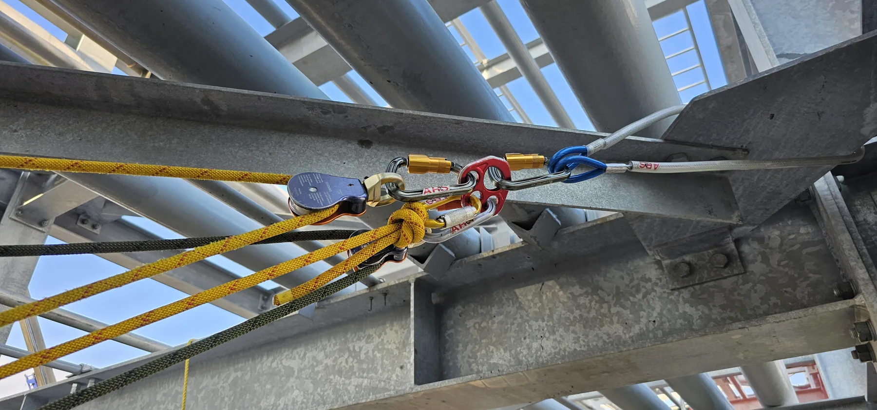Pulley and rope system rigged from a structural steel beam on an industrial site