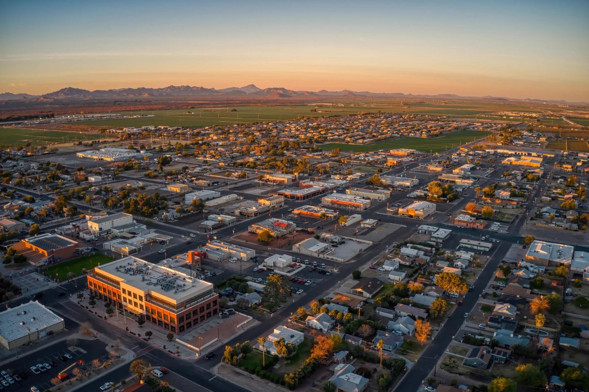 Aerial view of downtown Buckeye, Arizona at golden hour with the White Tank Mountains beyond