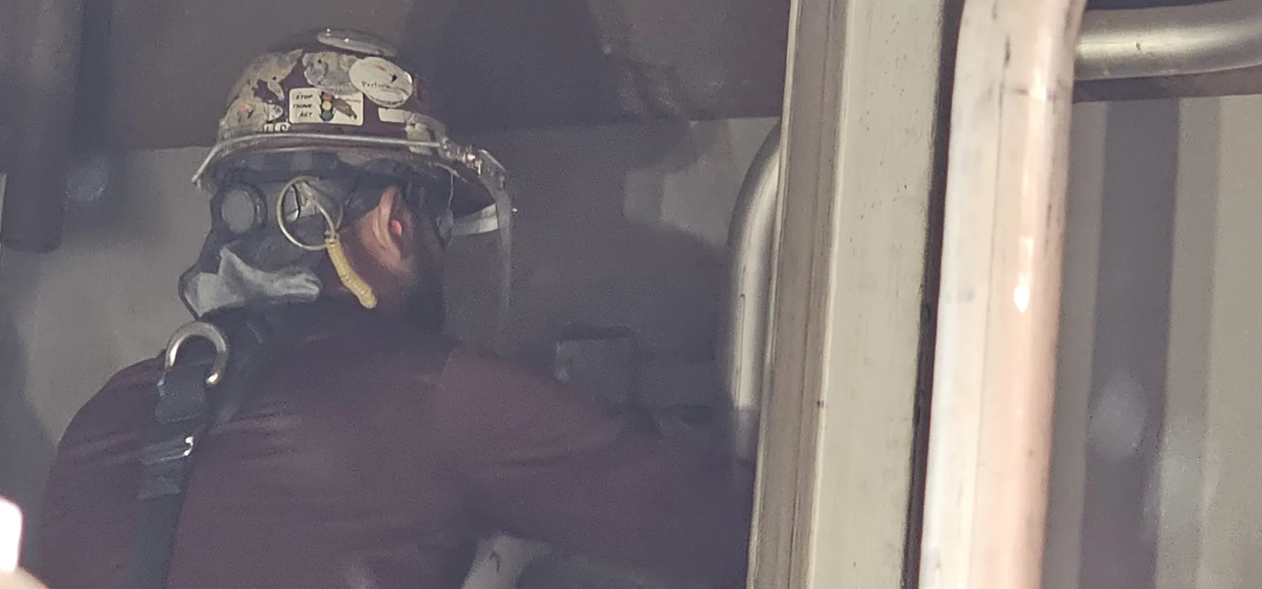 Technician wearing a helmet and respiratory protection during a site task